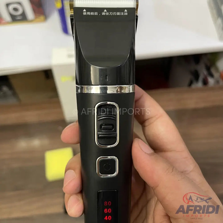 A black electric hair clipper with a digital display and adjustable blade.