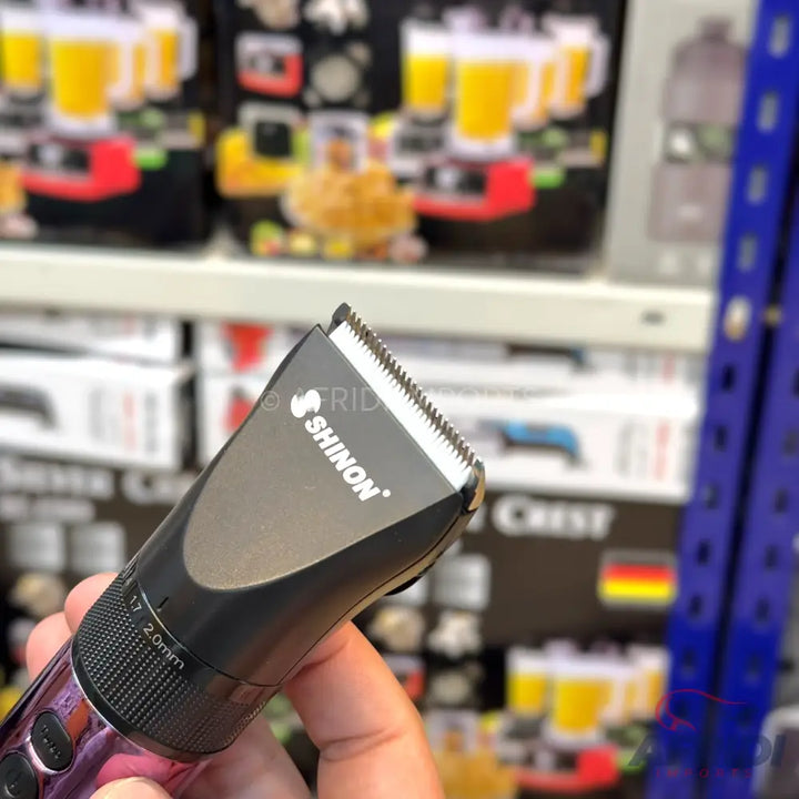 A black and silver ’SHINON’ branded hair clipper with an adjustable cutting length.