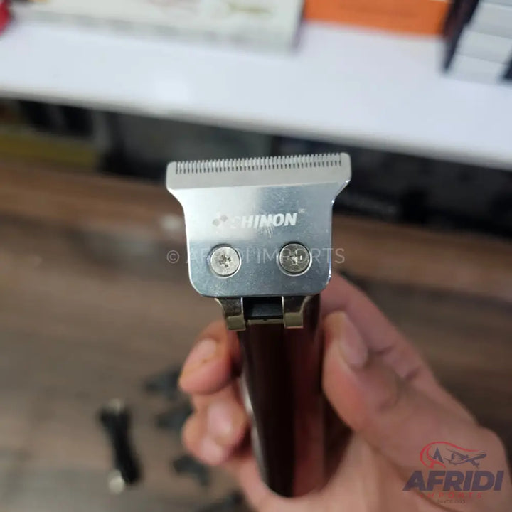 Close-up of a silver-bladed hair trimmer with a dark brown handle.