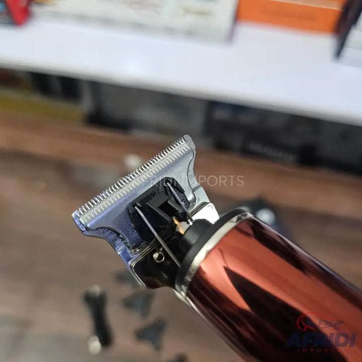 A close-up of a metallic rose gold hair trimmer with a silver blade.