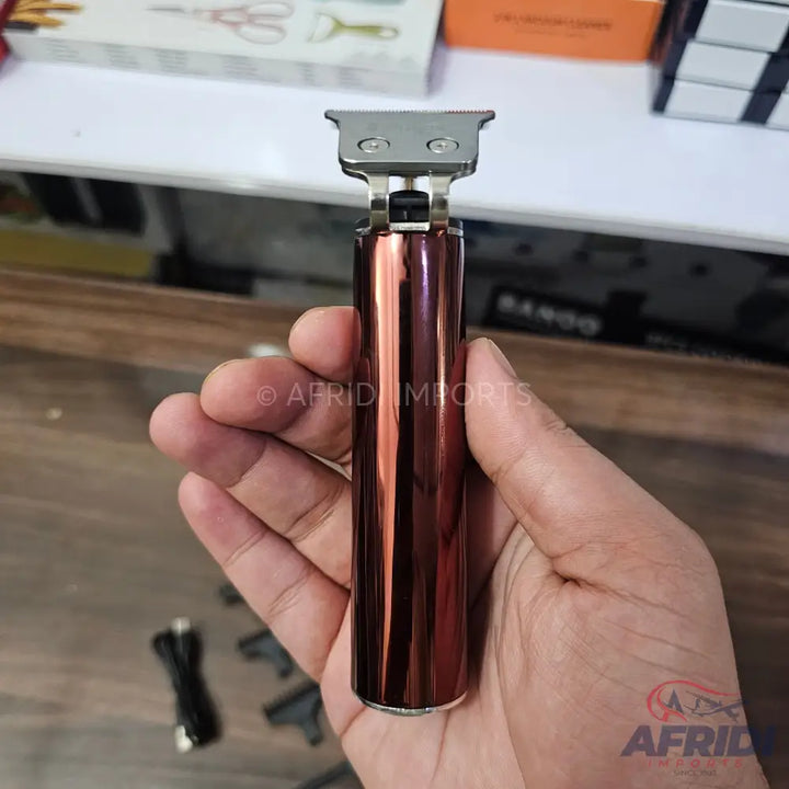 A rose gold metallic electric hair trimmer with a T-blade.