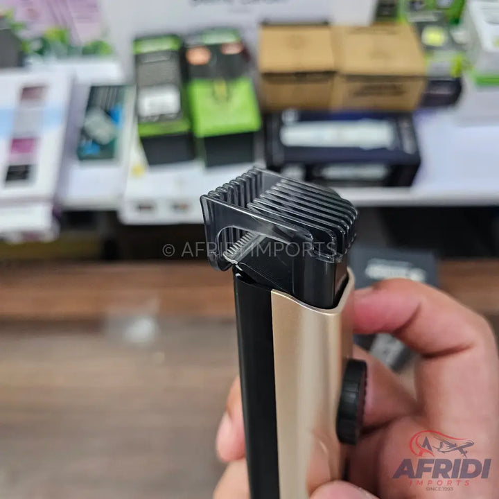 A gold and black electric beard trimmer with an adjustable comb attachment.