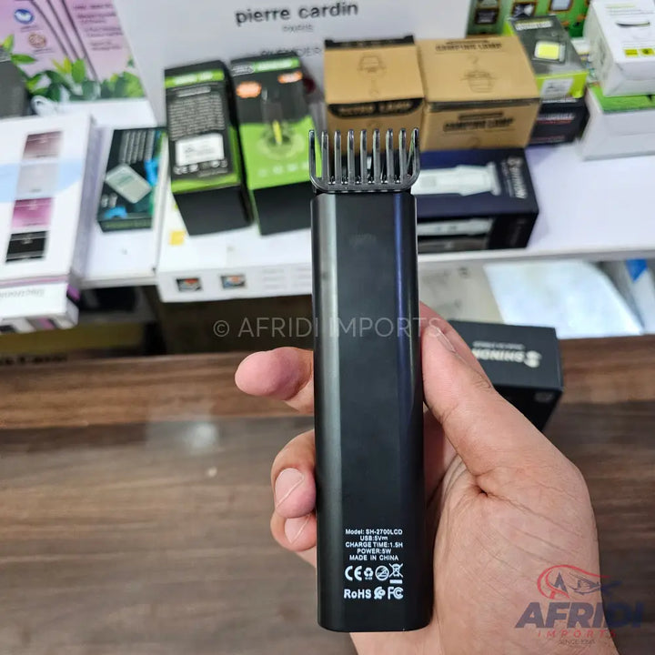 Black electric hair trimmer with a comb attachment.
