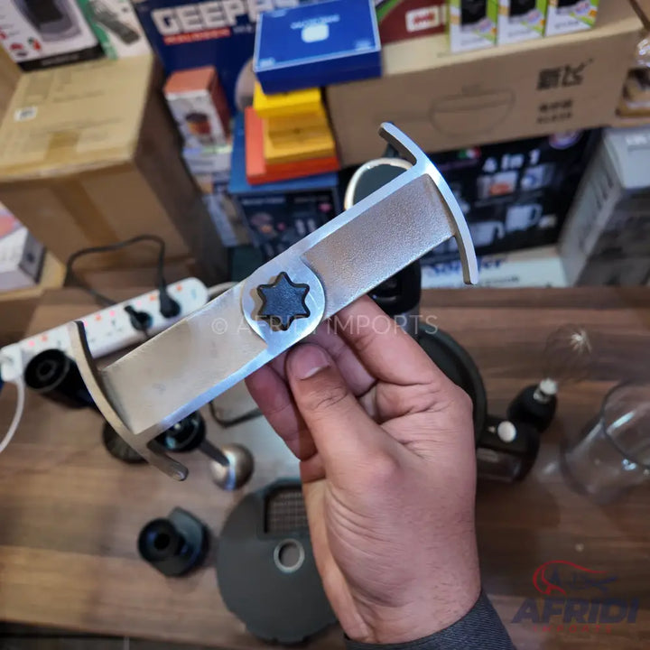 A metal blade with a six-point star-shaped attachment in the center, designed for a food processor or similar kitchen appliance.