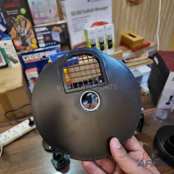Black, round plastic cover with a rectangular grated opening and a circular hole.