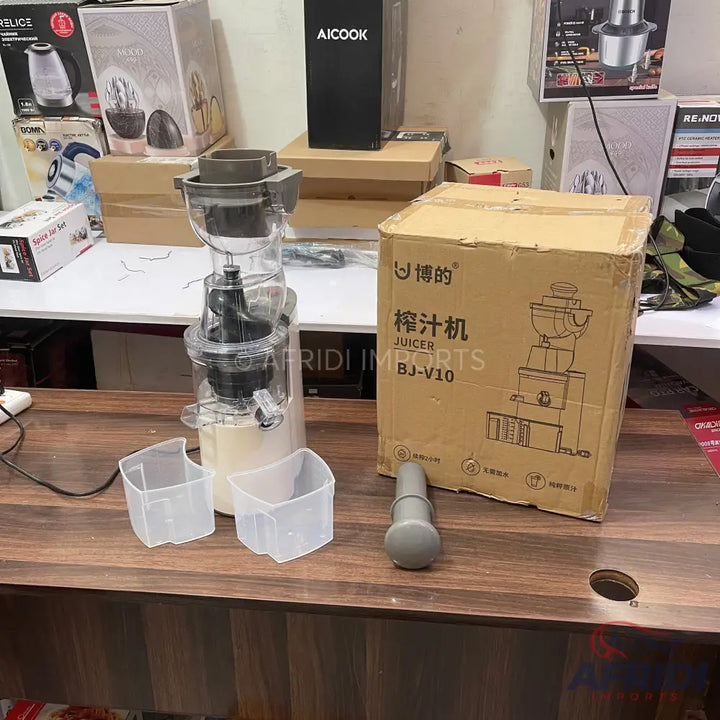 A masticating juicer with a clear top assembly and two transparent collection cups.
