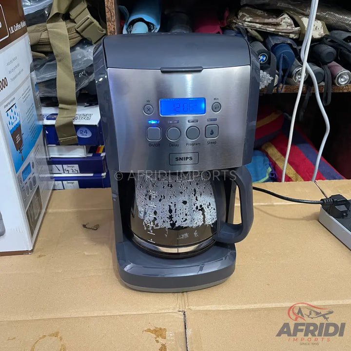 A grey and silver coffee maker with a glass carafe of brewed coffee.