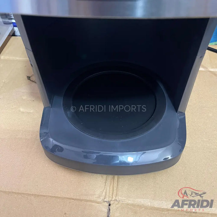 A dark grey coffee machine base with a circular drip tray.