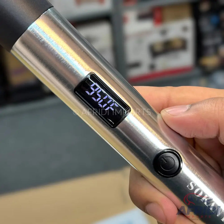 A silver-colored hair styling tool with a digital display showing ’950°F’ and a power button.