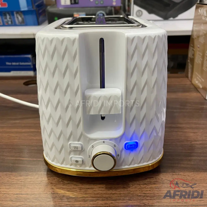 A white two-slice toaster with a textured pattern, gold-colored trim, and a blue indicator light.