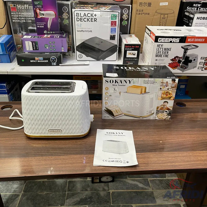 A white two-slice toaster with a textured surface and gold trim.