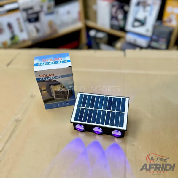 A solar-powered garden light with three purple LED spotlights.