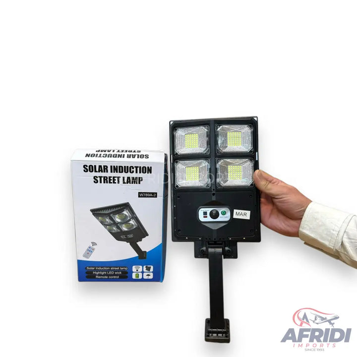 A solar induction street lamp with four LED panels and an adjustable bracket.