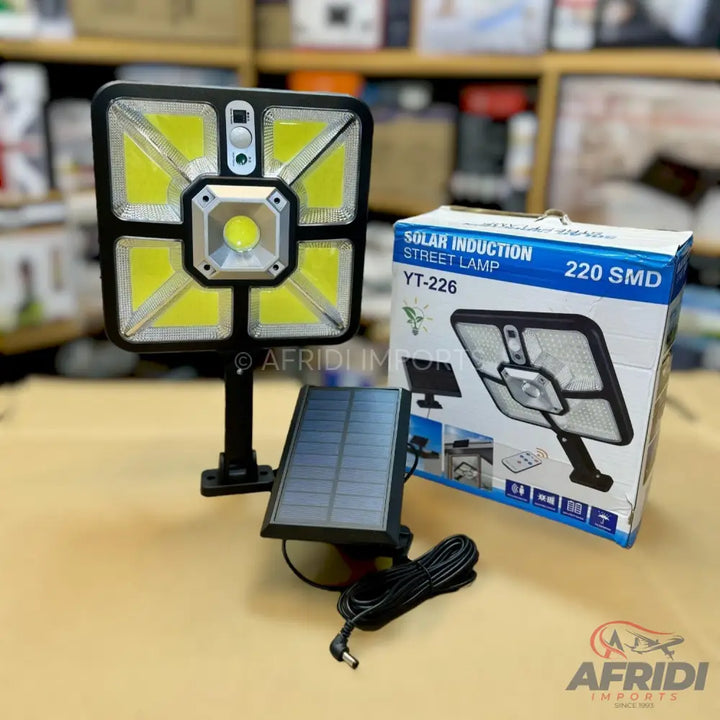 A black square solar induction street lamp with a separate solar panel.