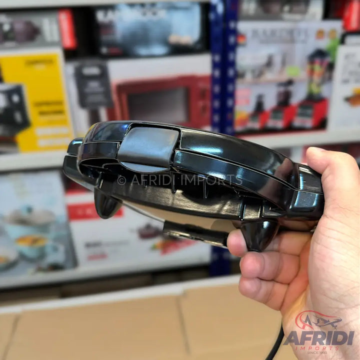 A black, portable, folding hair straightener.
