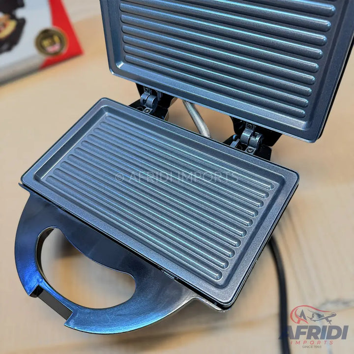 An open electric grill with ridged non-stick cooking plates.