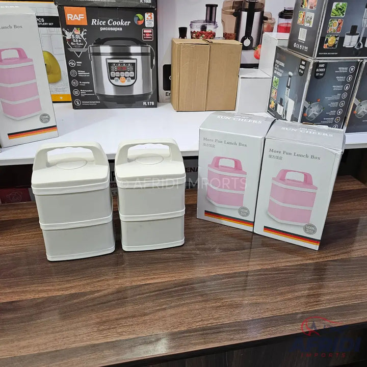 Two grey, two-tiered lunch boxes with white lids and handles.