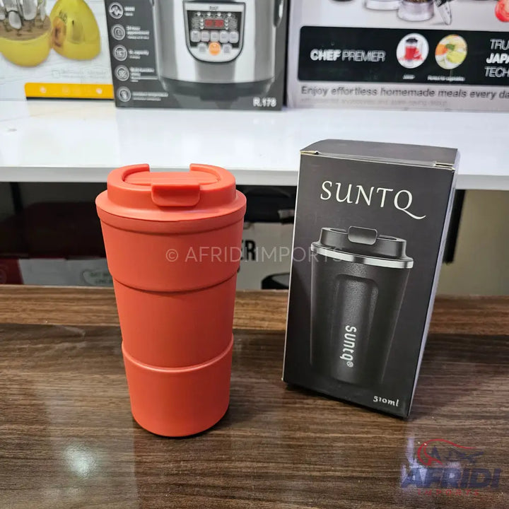 An orange travel mug with a flip-top lid and a black boxed travel mug.