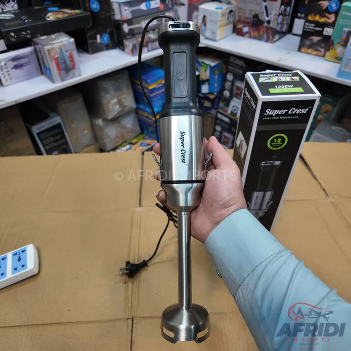 A stainless steel immersion blender with a black handle.