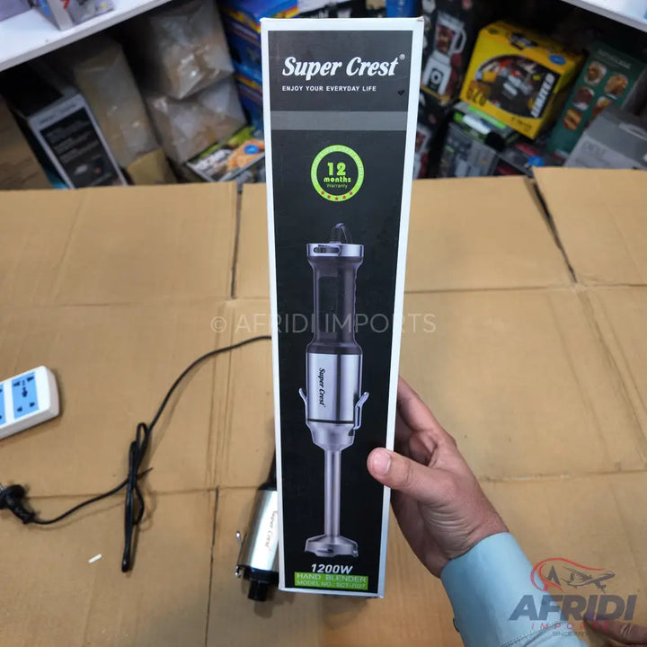 A boxed ’Super Crest’ immersion blender with a 1200W motor and a 12-month warranty.