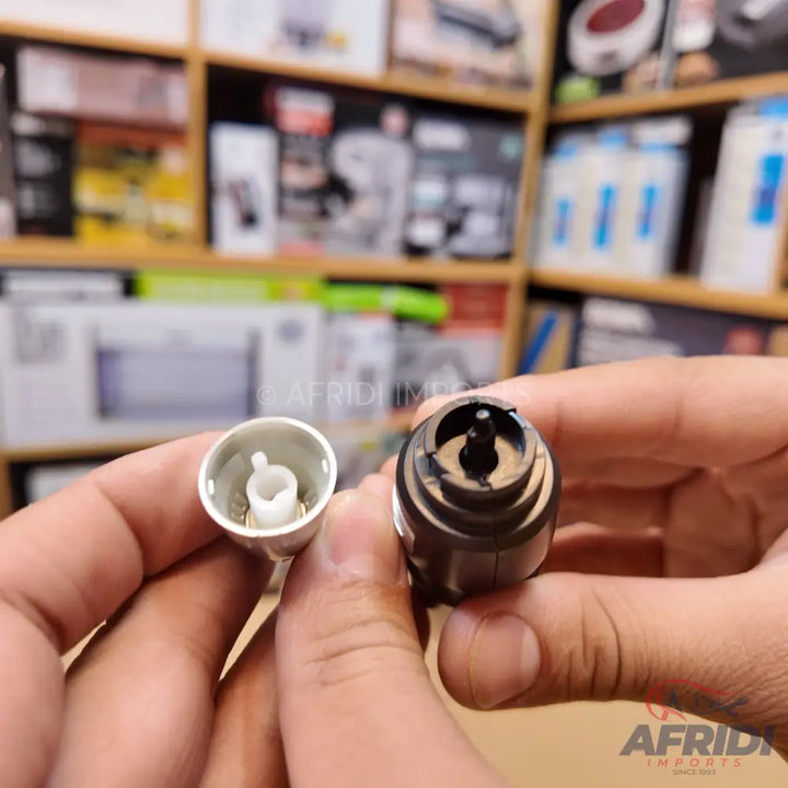 Two disassembled parts of a blender or mixer coupling, one white and one dark, held in hands.