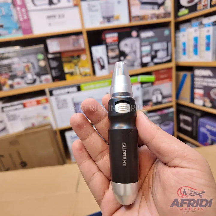 Black and silver electric nose and ear hair trimmer held in a hand.
