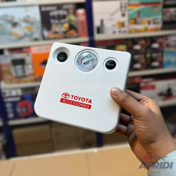 A white portable tire inflator with a pressure gauge and two buttons.