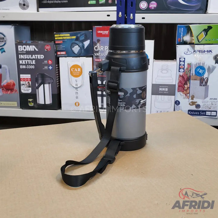 Silver and black insulated kettle with a carrying strap.