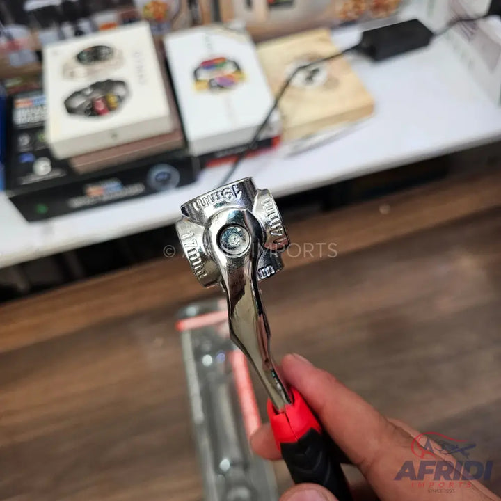 A multi-size ratchet wrench with a chrome finish and a red and black handle.