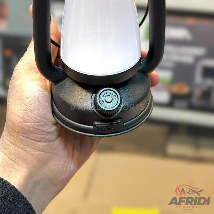 A black base lantern with a white light-emitting top, featuring an ’off/on’ dial for control.