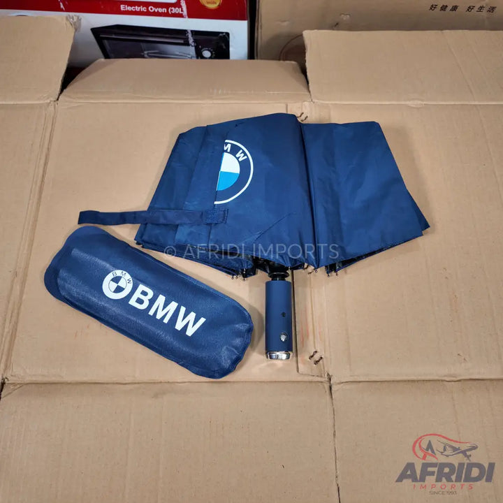 A navy blue umbrella with a matching sleeve, both featuring the BMW logo.