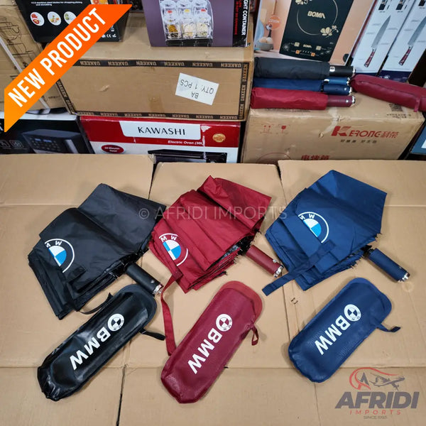 Foldable BMW-branded umbrellas in black, maroon, and navy blue.