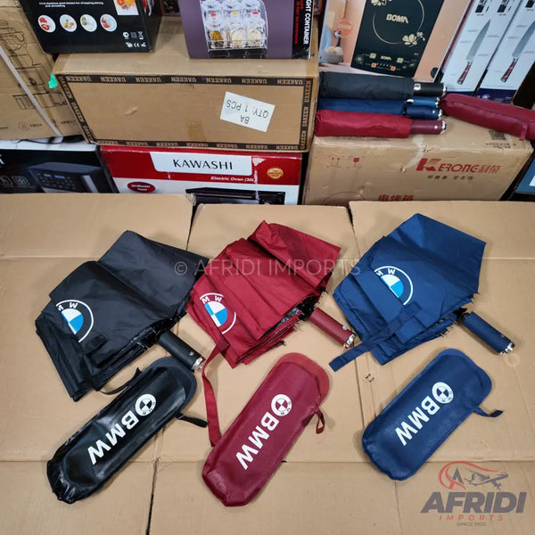 Foldable BMW-branded umbrellas in black, maroon, and navy blue.