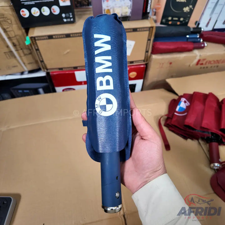 Blue umbrella with a white BMW logo and text.