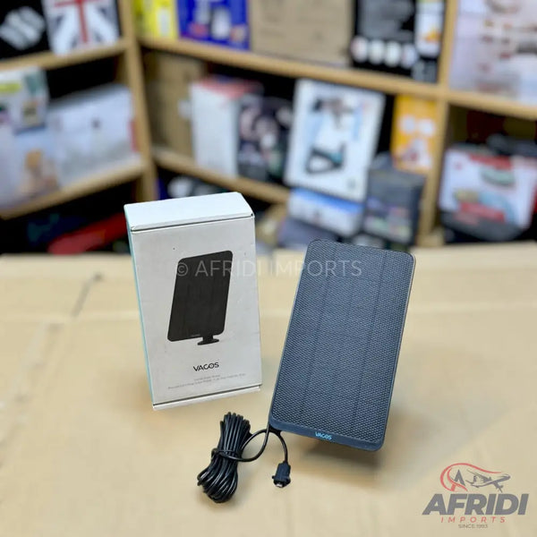 A rectangular, dark grey, portable speaker with a black charging cable.