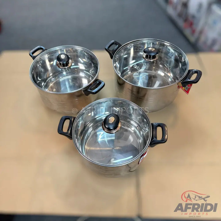 A set of three stainless steel cooking pots with glass lids and black handles.