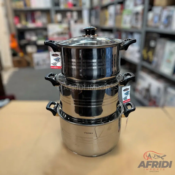 A set of three stainless steel cooking pots with lids and black handles.