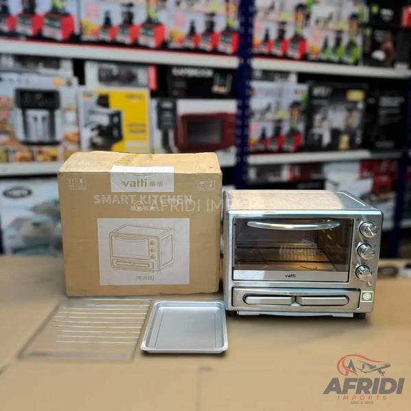 A silver countertop toaster oven with a pull-out crumb tray, along with its packaging and accessories.