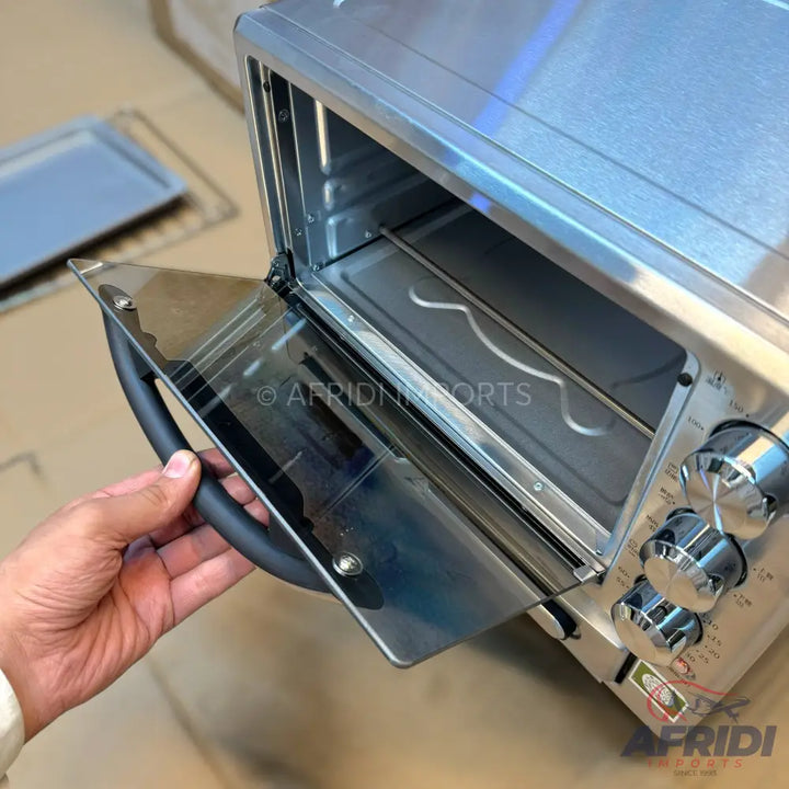 Stainless steel toaster oven with an open glass door and control knobs.