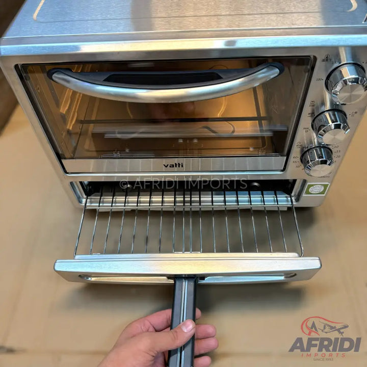 A stainless steel toaster oven with a clear glass door, three control knobs on the right side, and a pull-out crumb tray.