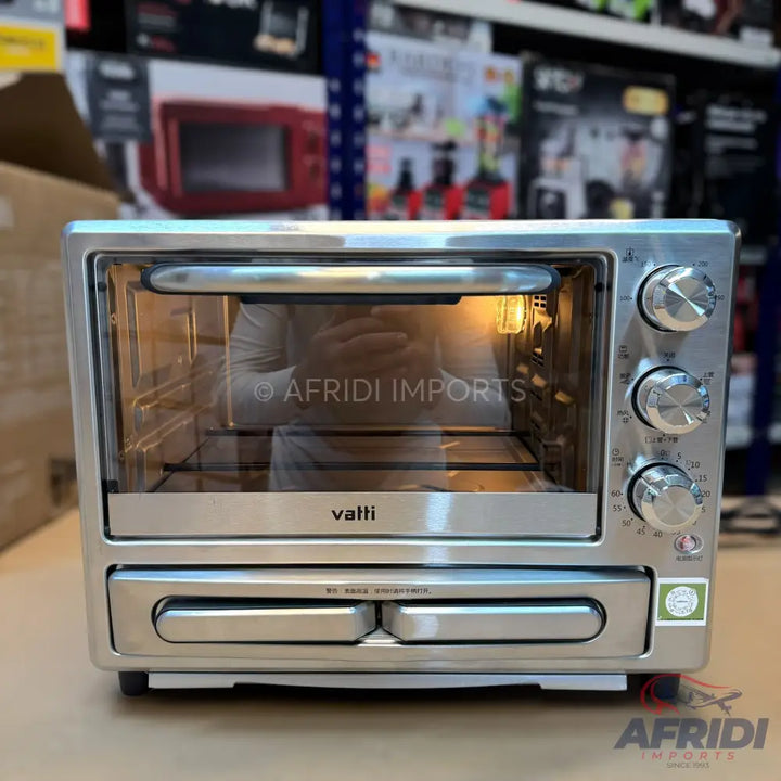 Silver-colored toaster oven with three control knobs and a lower warming drawer.