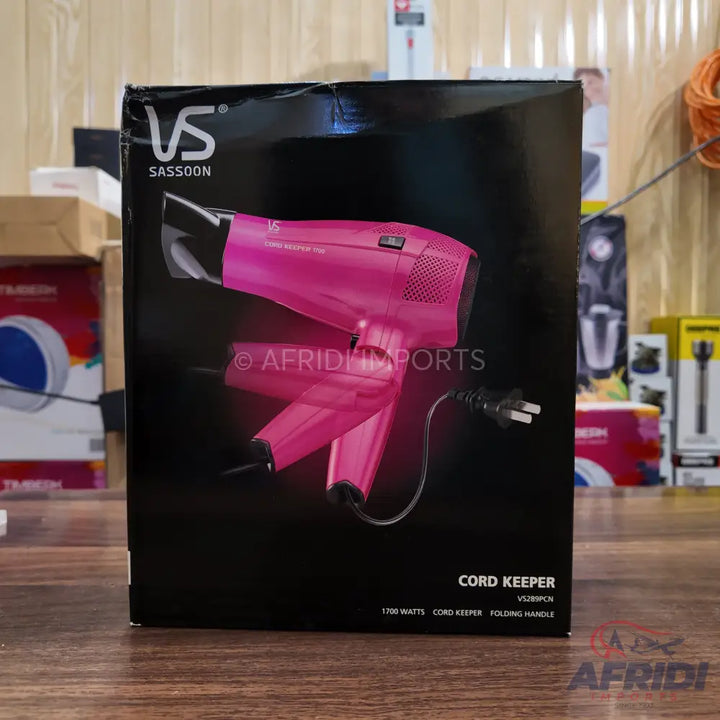 Pink hairdryer in its black retail packaging.