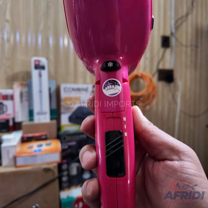 Pink hair dryer with adjustable heat and speed settings.