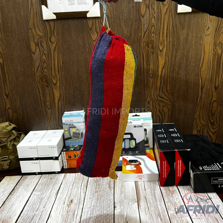 A colorful, striped hammock in a drawstring bag.