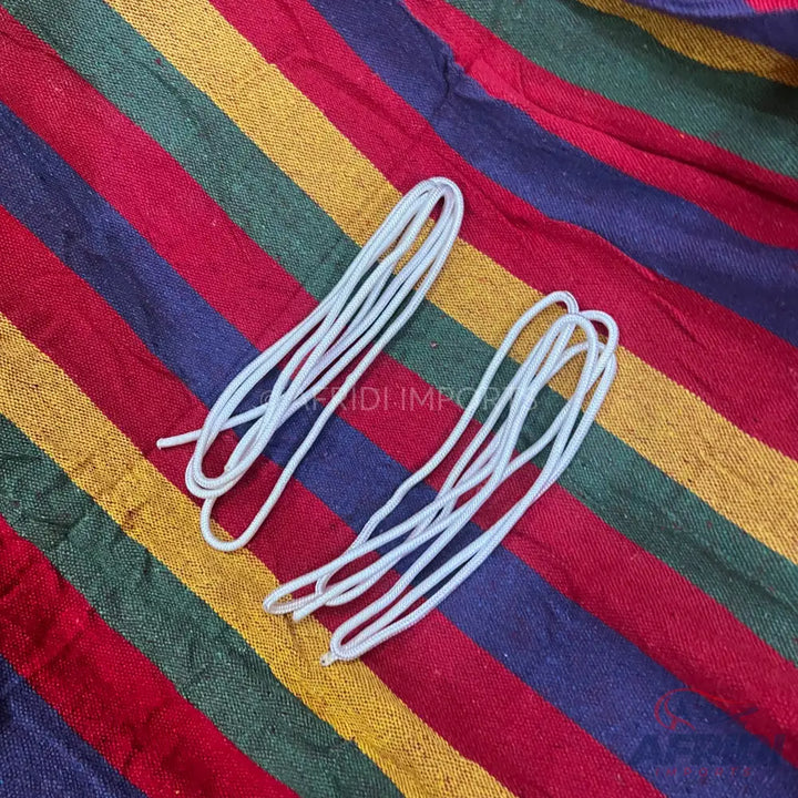 Two bundles of white rope on a striped fabric.