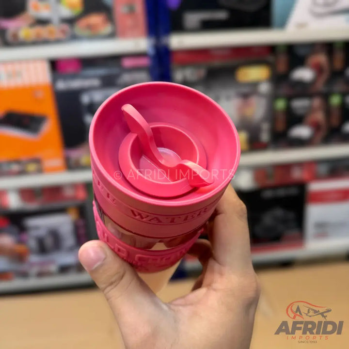 Pink plastic shaker bottle with an internal mixing whisk.