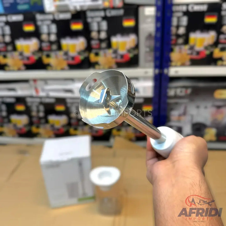Stainless steel immersion blender with a white handle.