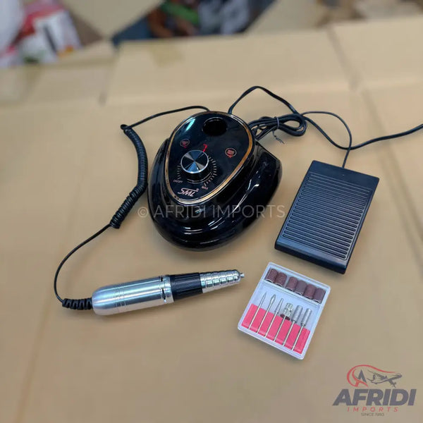 A black electric nail drill machine with a foot pedal, handpiece, and a set of drill bits.
