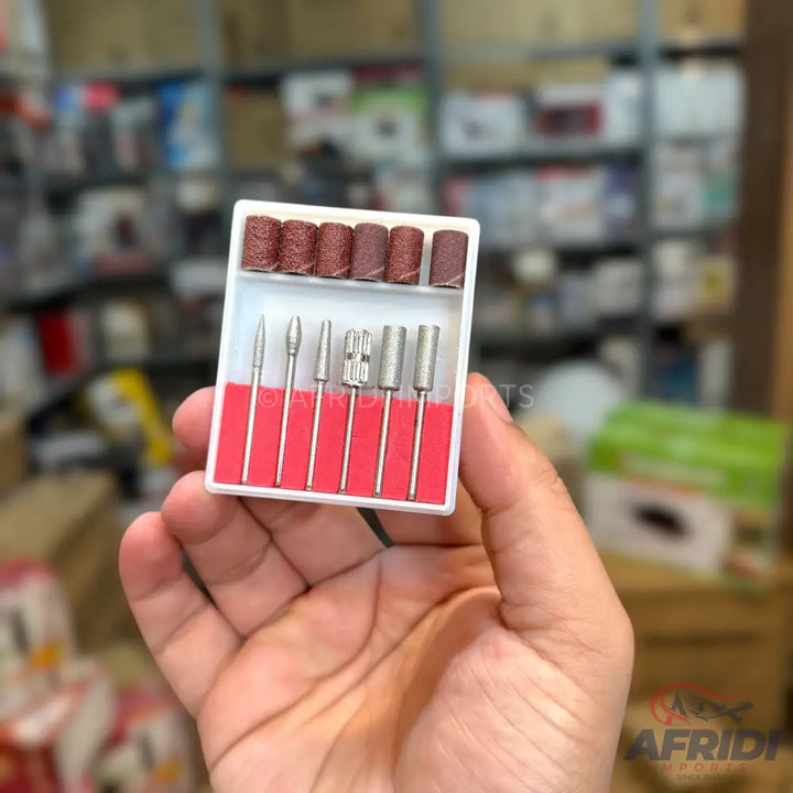 A set of nail drill bits and sanding bands in a white case.