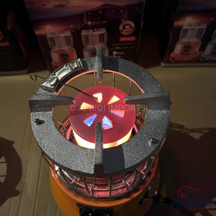 A lit portable gas stove with a black cast iron top and a red glowing burner.